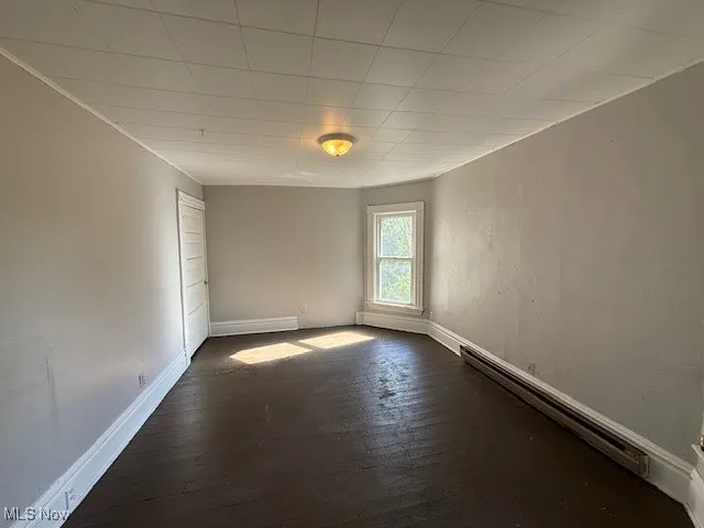 Apartment 3 Empty room featuring dark wood-style flooring and baseboard heating