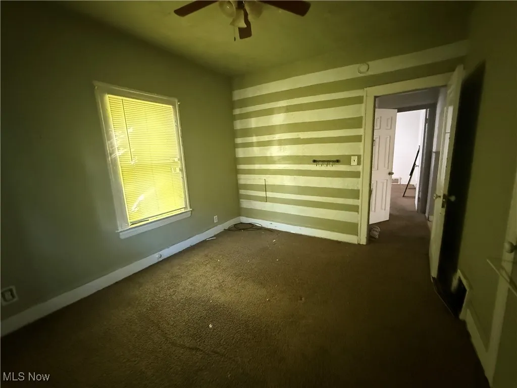 Bedroom 2, featuring dark colored carpet and ceiling fan