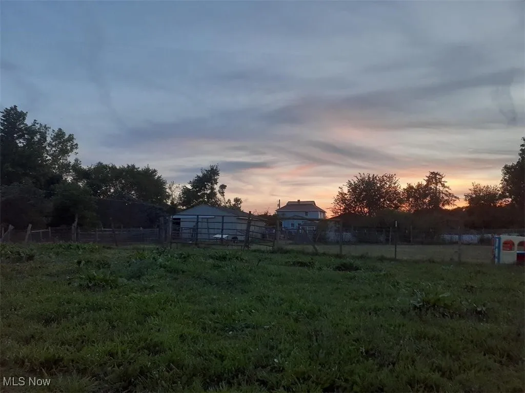 View of yard with an outbuilding, a rural view, and view of wooded area