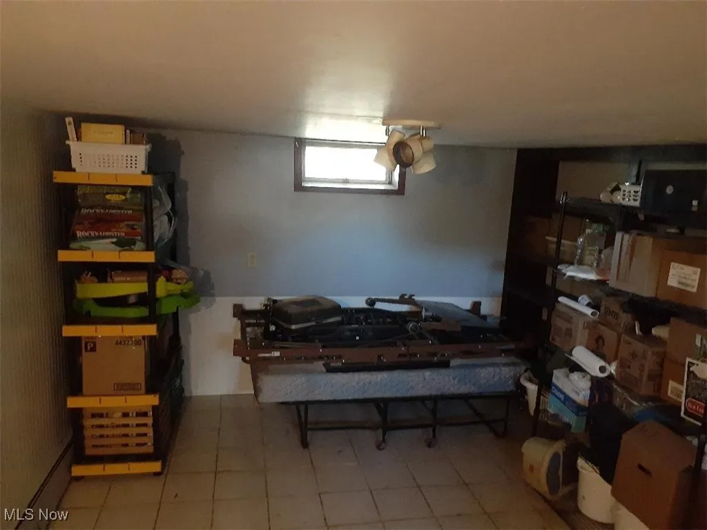  featuring light tile patterned floors and a baseboard radiator