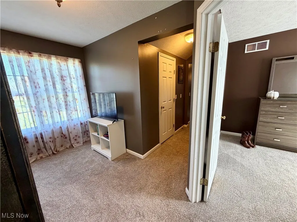 Bedroom with a textured ceiling and carpet flooring
