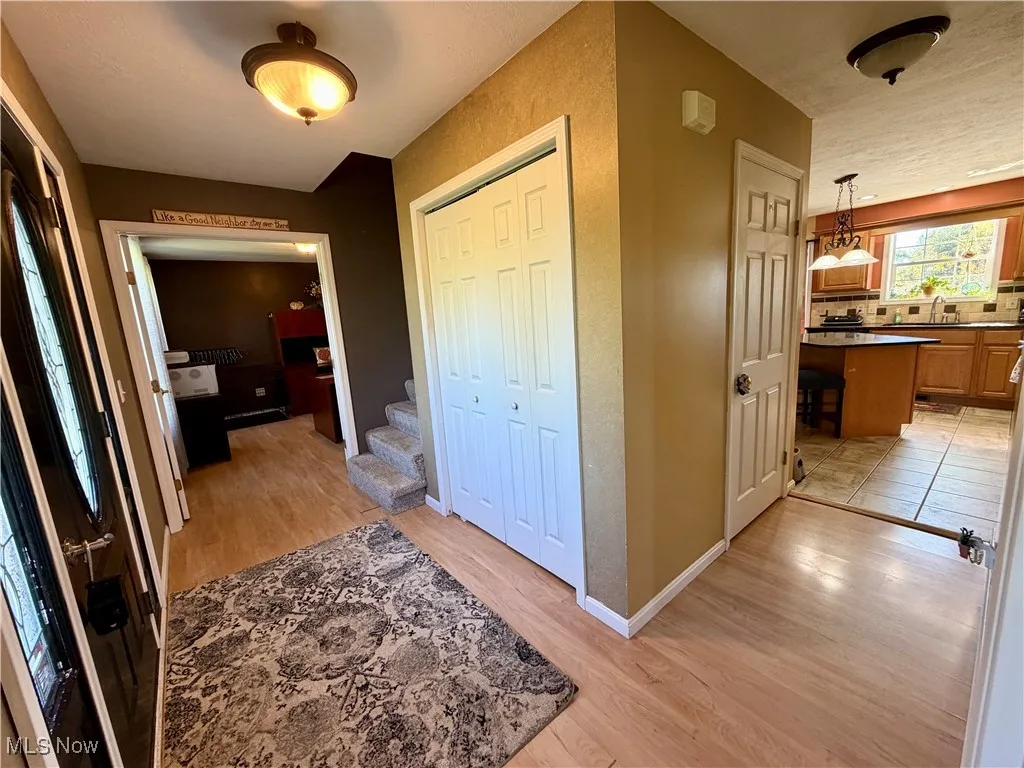 Hall with light wood-style flooring and stairs