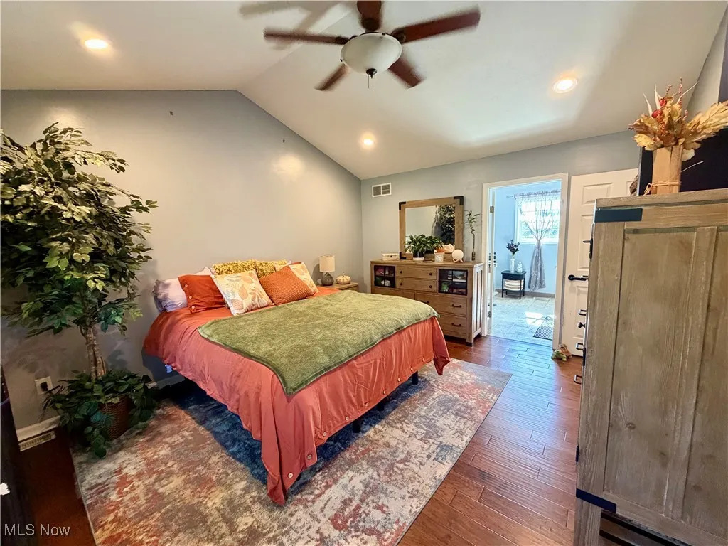 Bedroom with vaulted ceiling, hardwood / wood-style floors, recessed lighting, and ceiling fan