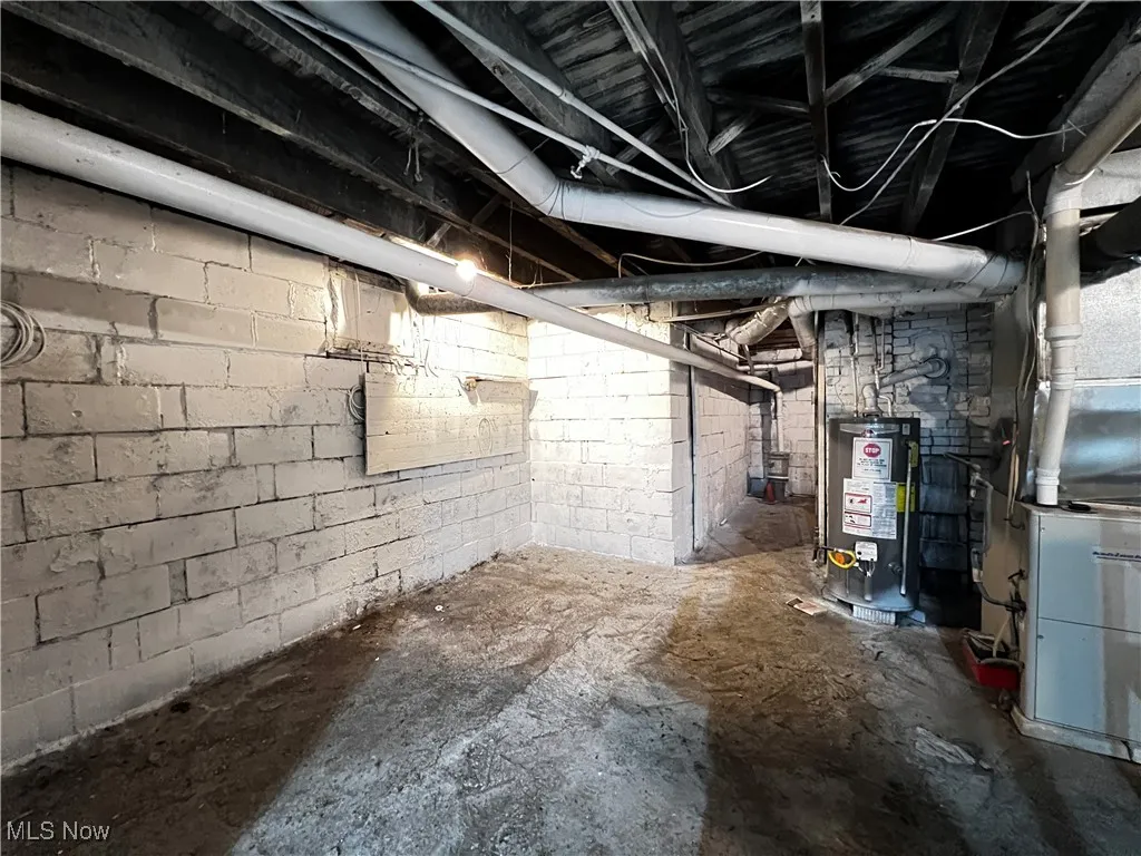 Unfinished basement featuring gas water heater and heating unit