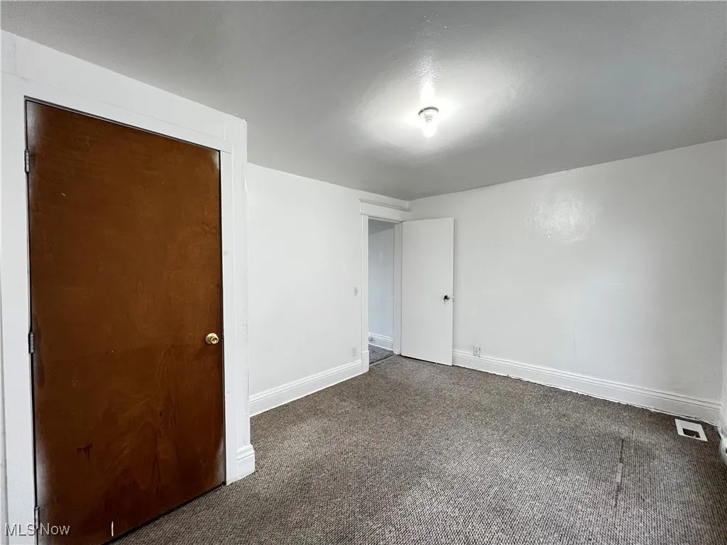 Carpeted spare room with baseboards