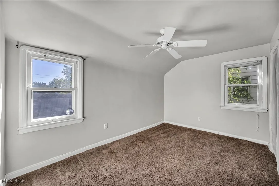 Bedroom with ceiling fan, carpet, and natural light