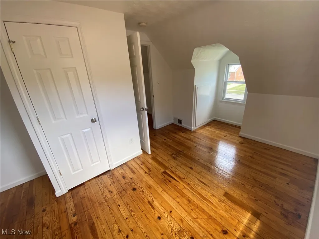 Bonus room featuring light wood finished floors and vaulted ceiling