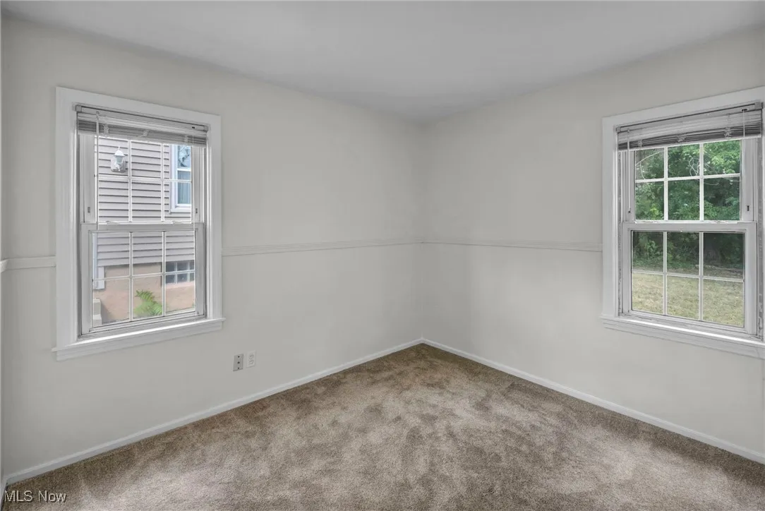 Carpeted spare room with baseboards