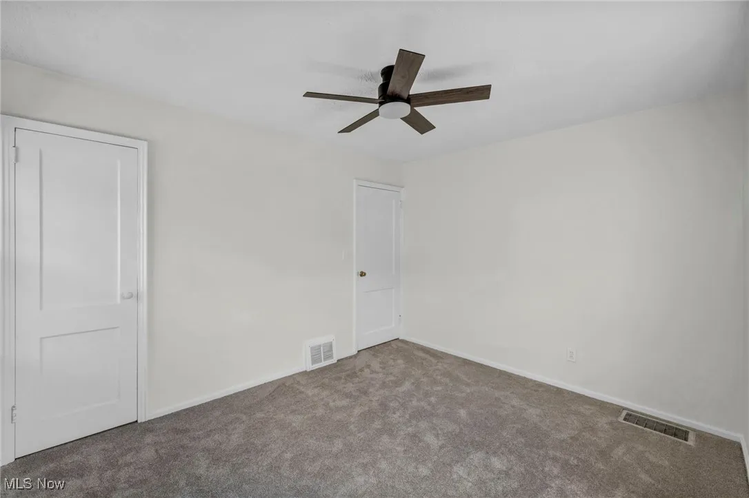 Unfurnished bedroom with carpet and a ceiling fan