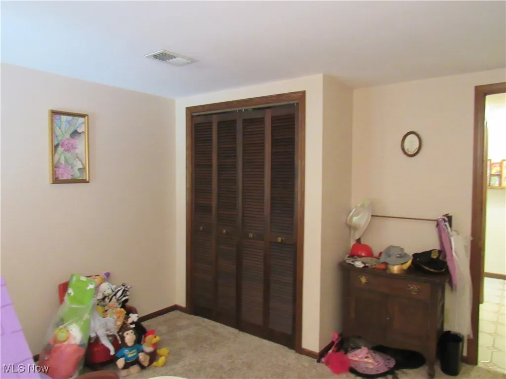 Carpeted bedroom featuring a closet