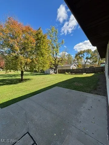 back patio view of one shed and garden beds
