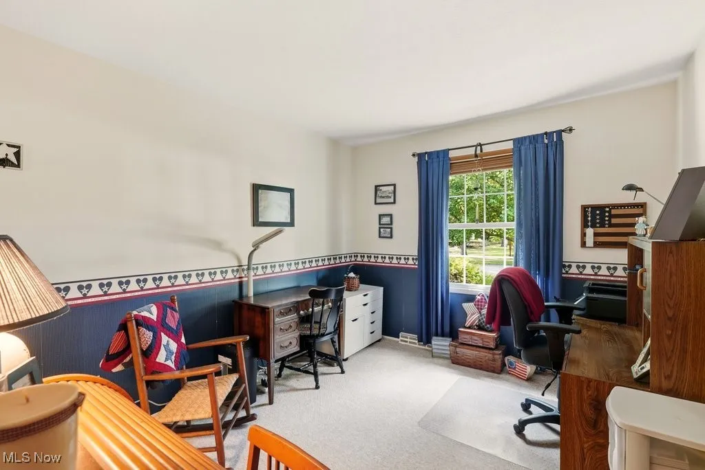Carpeted office space featuring wainscoting