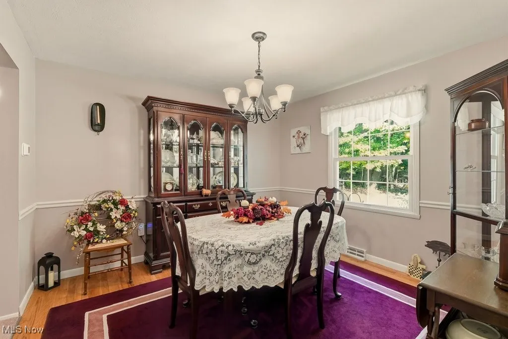 Dining room with light wood-style floors and a chandelier