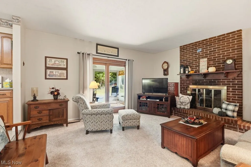 Living room with light colored carpet and a brick fireplace