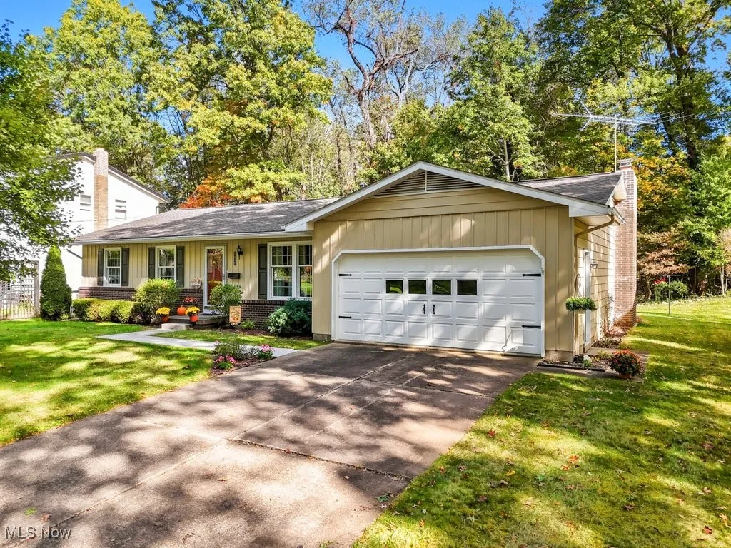 Ranch-style house featuring a front yard, brick siding, a chimney, and a porch
