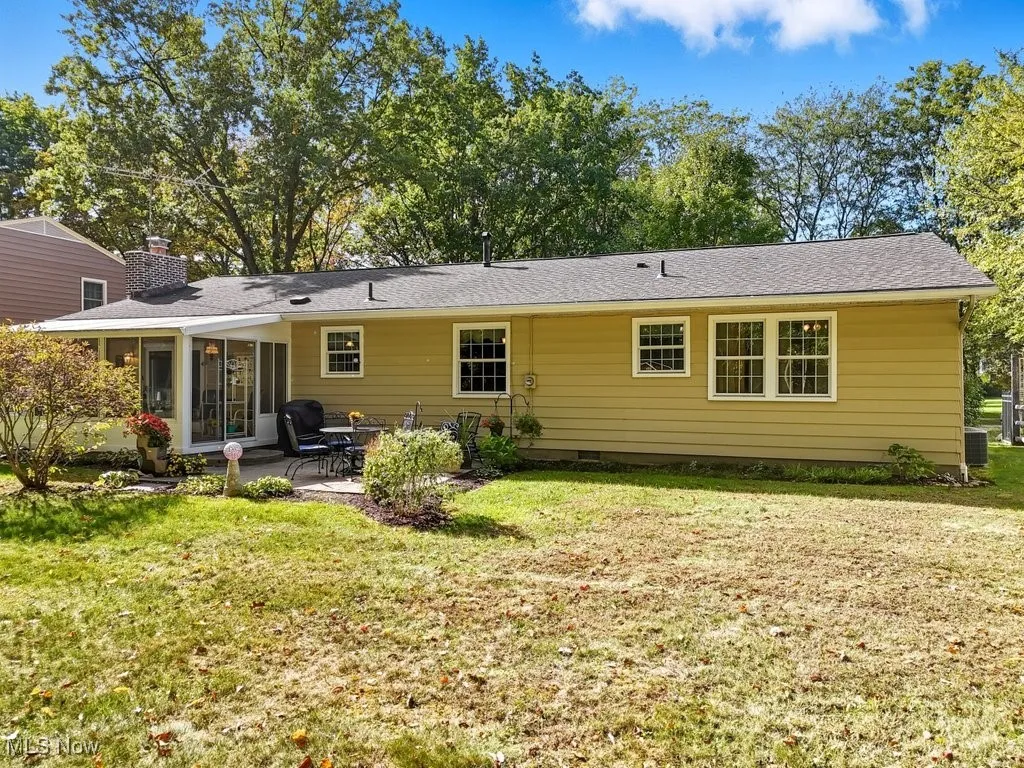 Rear view of property with a yard, a patio area, a sunroom, and crawl space