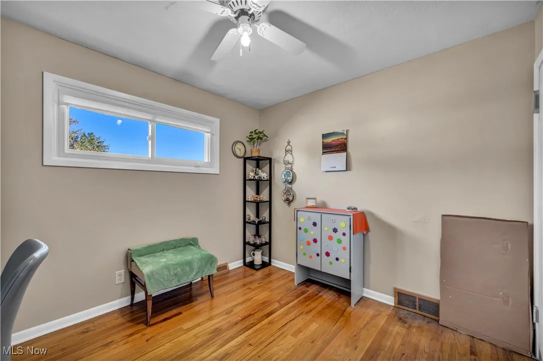 Living area with light wood-type flooring and a ceiling fan