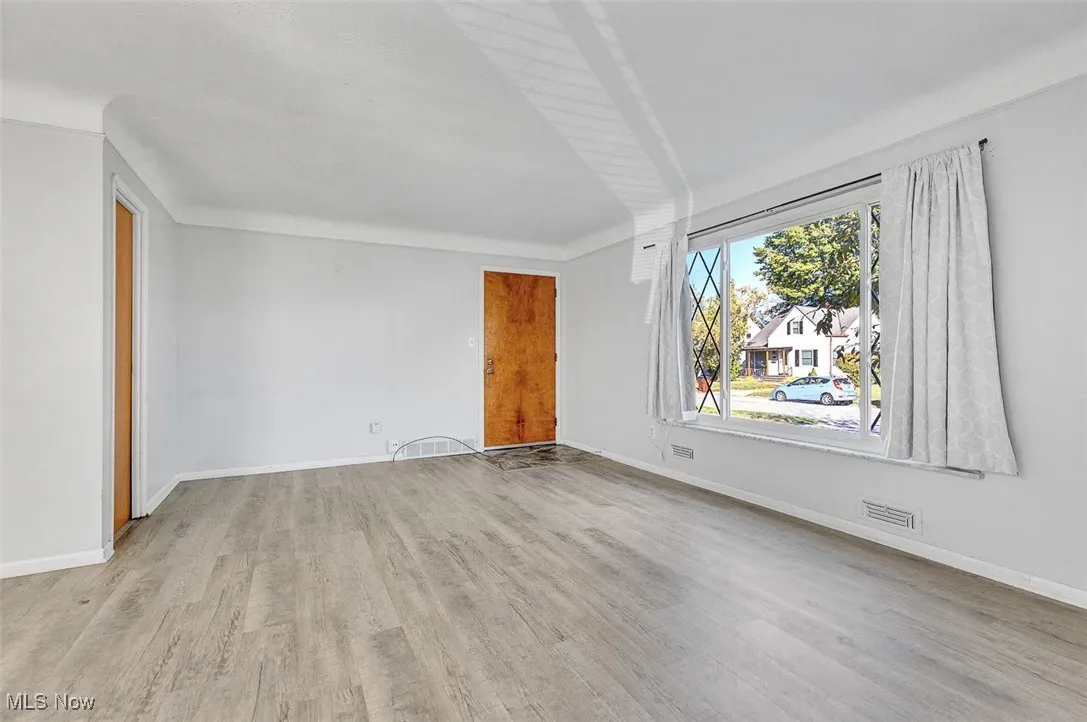 Empty room featuring baseboards and light wood-style flooring
