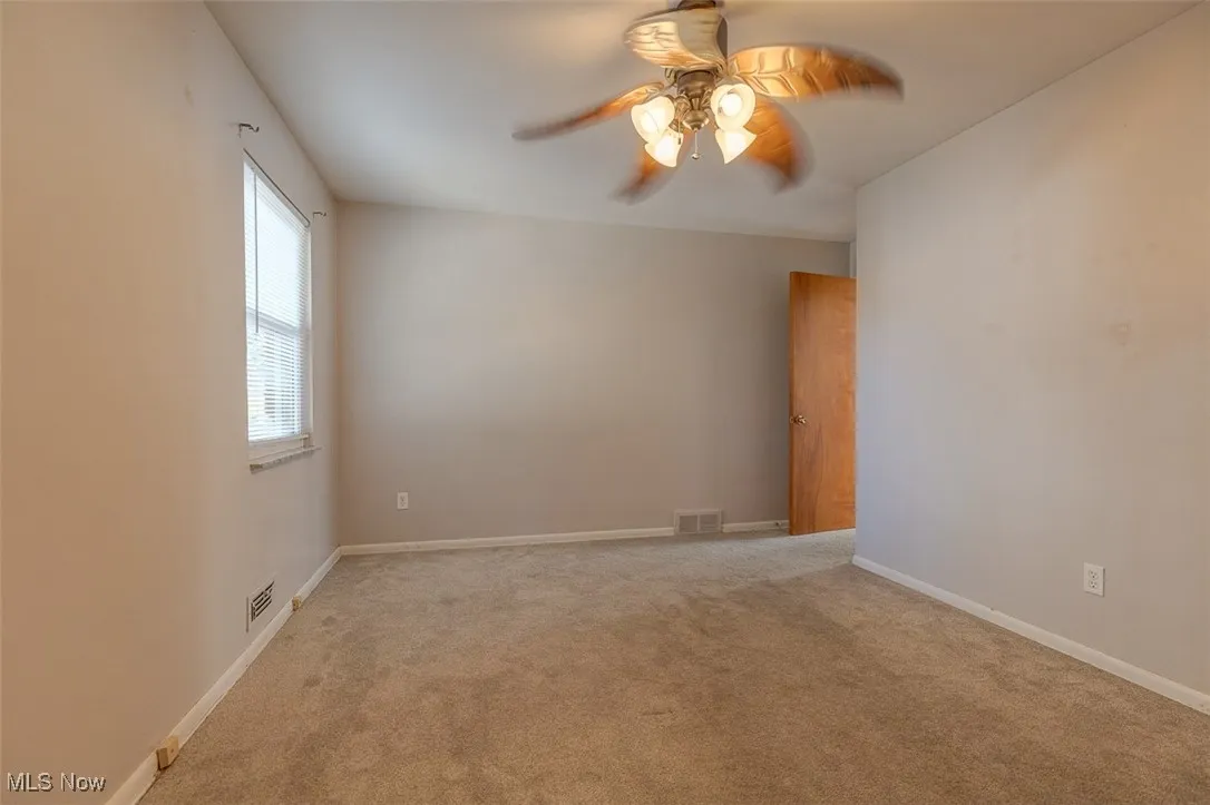 Spare room with light colored carpet and ceiling fan