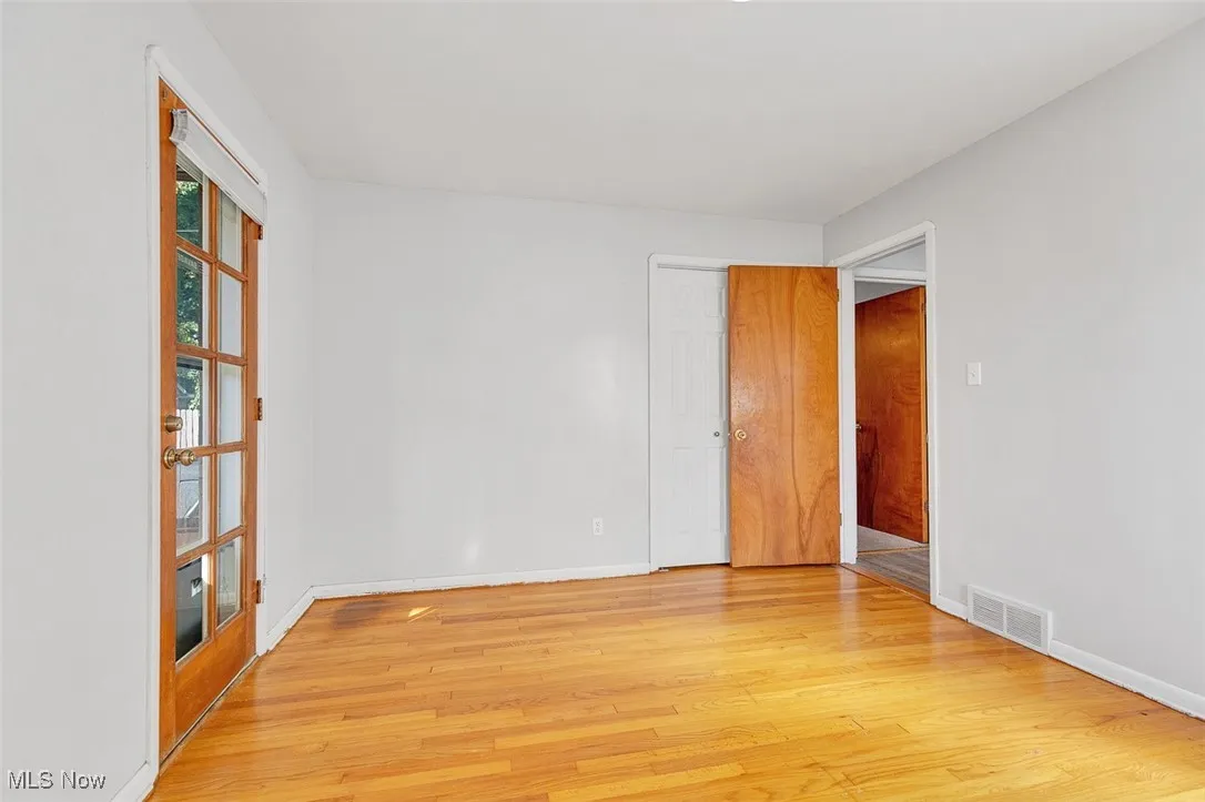 Empty room with light wood-type flooring and baseboards