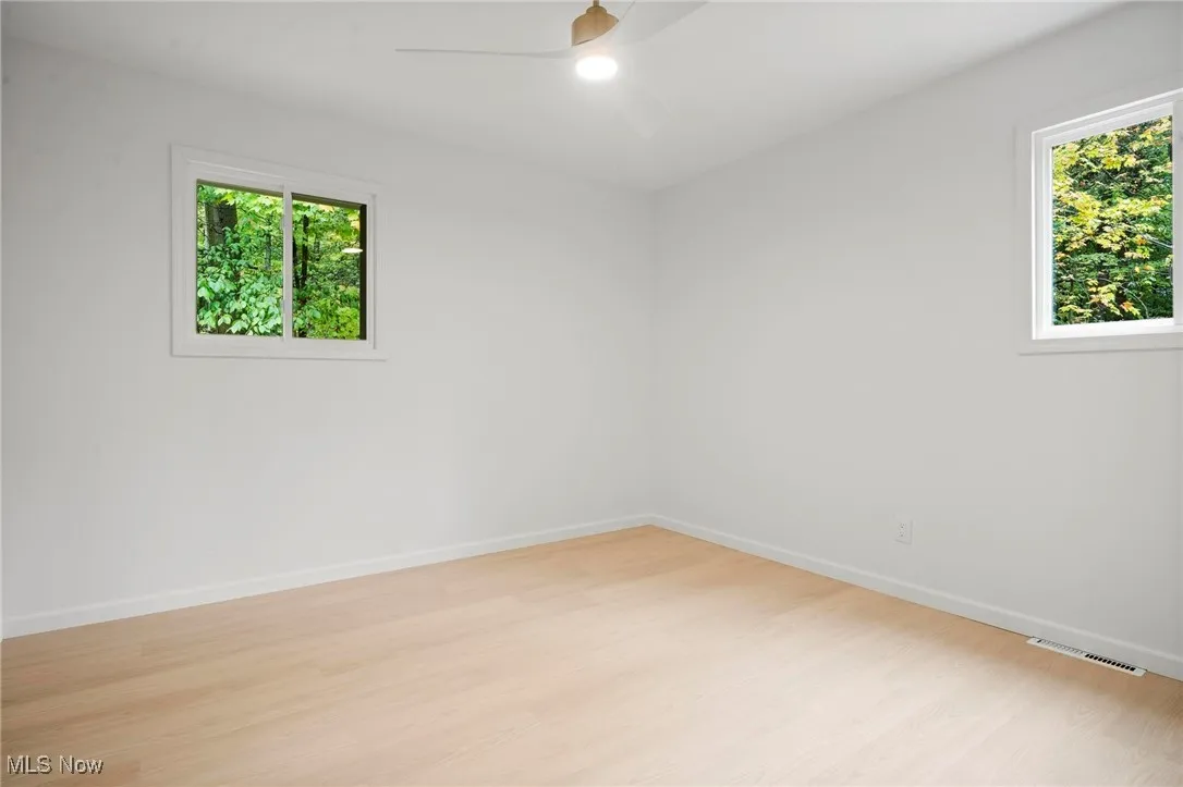 Empty room featuring light wood-type flooring and ceiling fan