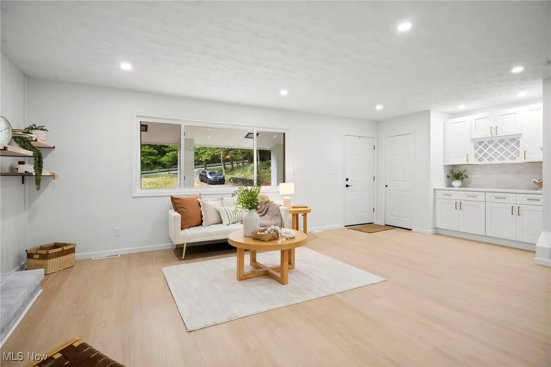 Living area with recessed lighting, light wood-style flooring, and a textured ceiling
