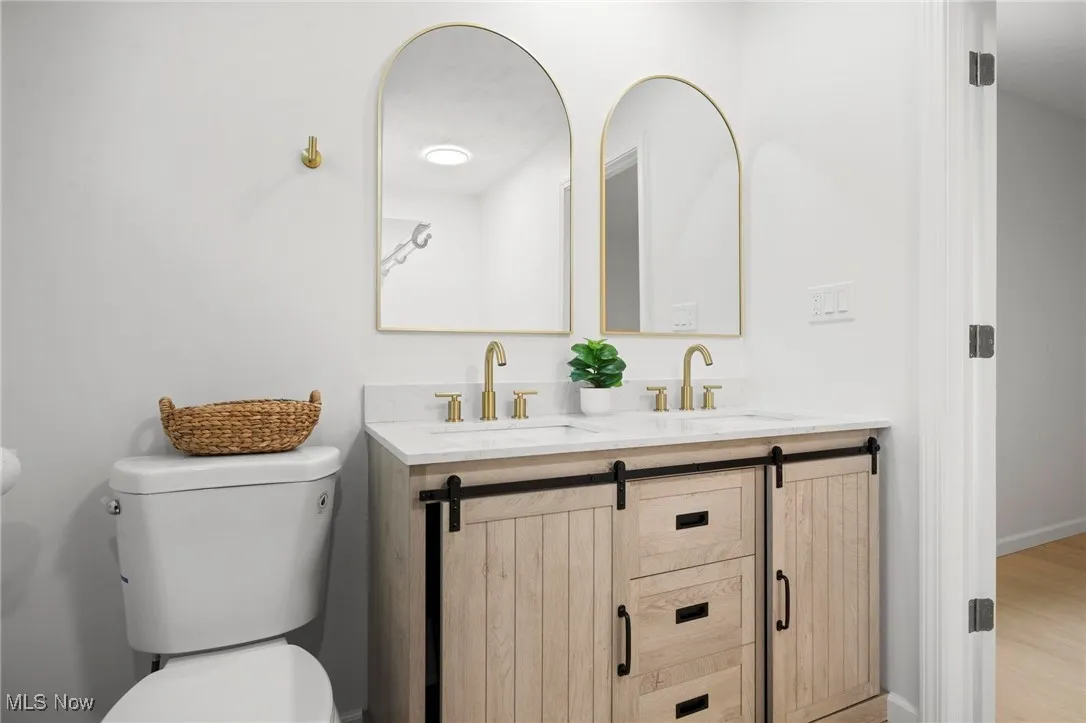 Full bath with double vanity and wood finished floors