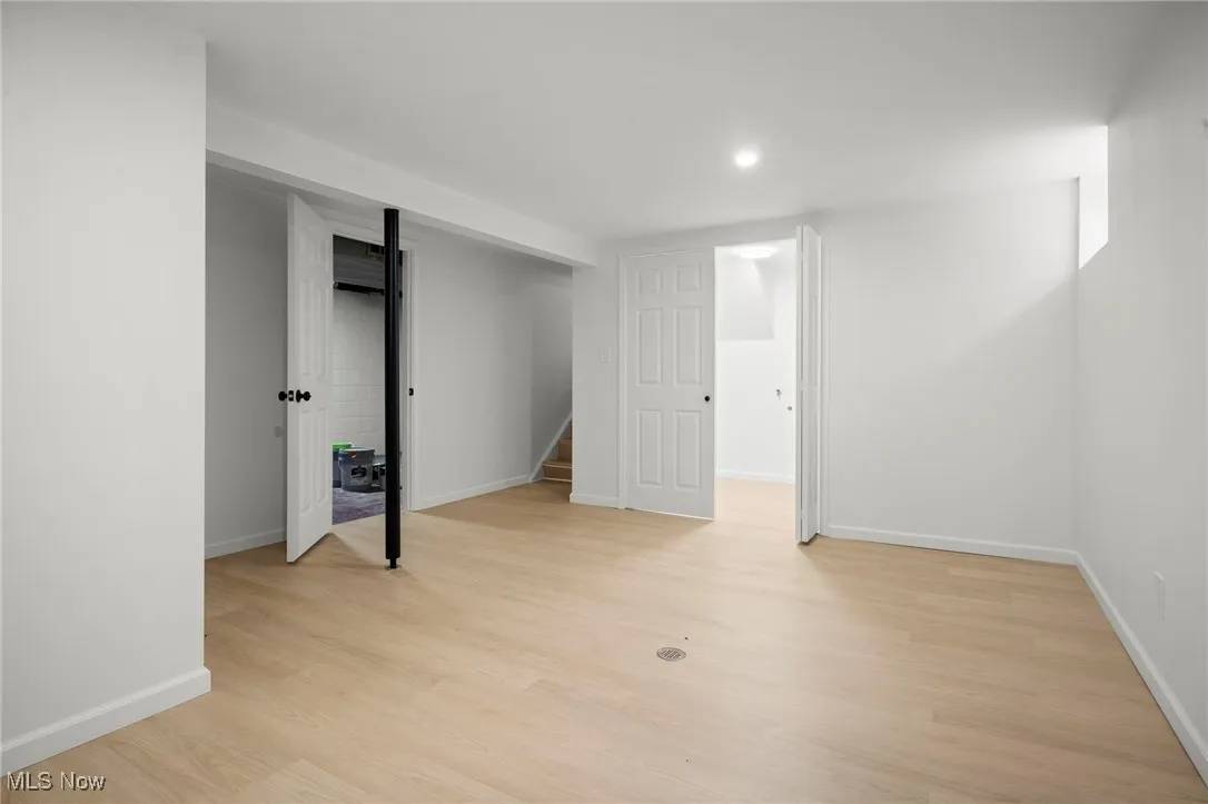 Finished below grade area with light wood-style flooring, stairway, and recessed lighting