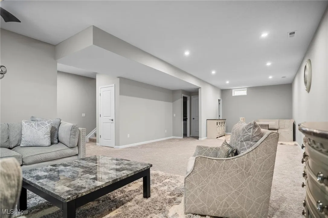 Carpeted living area featuring recessed lighting and baseboards