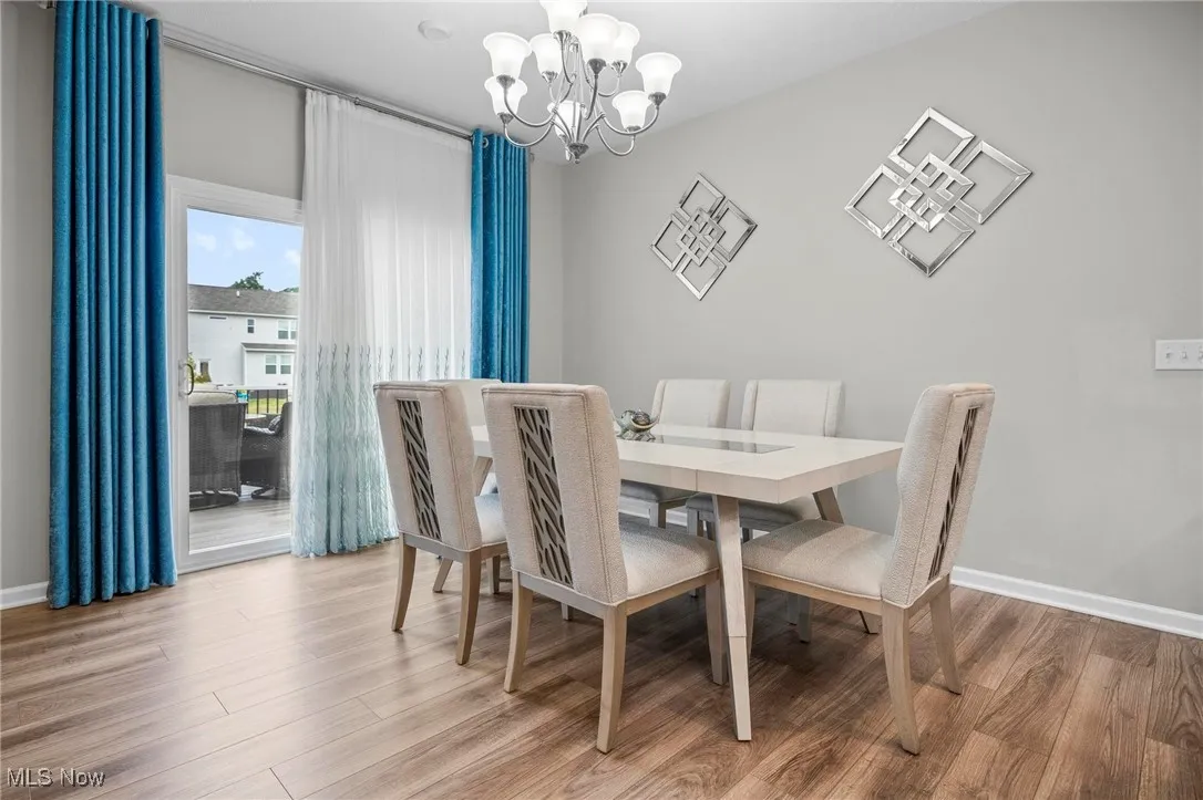 Dining space with light wood finished floors and a chandelier