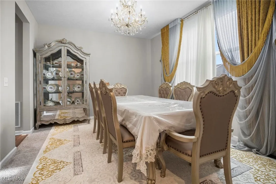 Dining space featuring a chandelier and light carpet