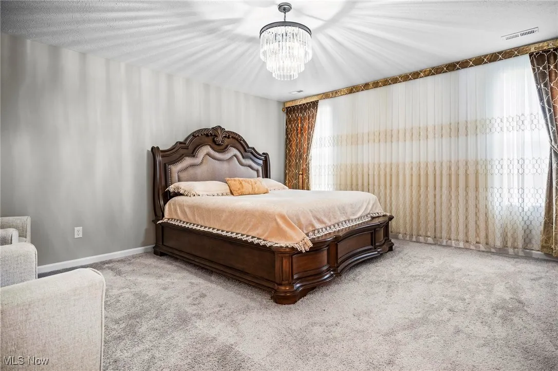 Bedroom featuring carpet flooring and a chandelier