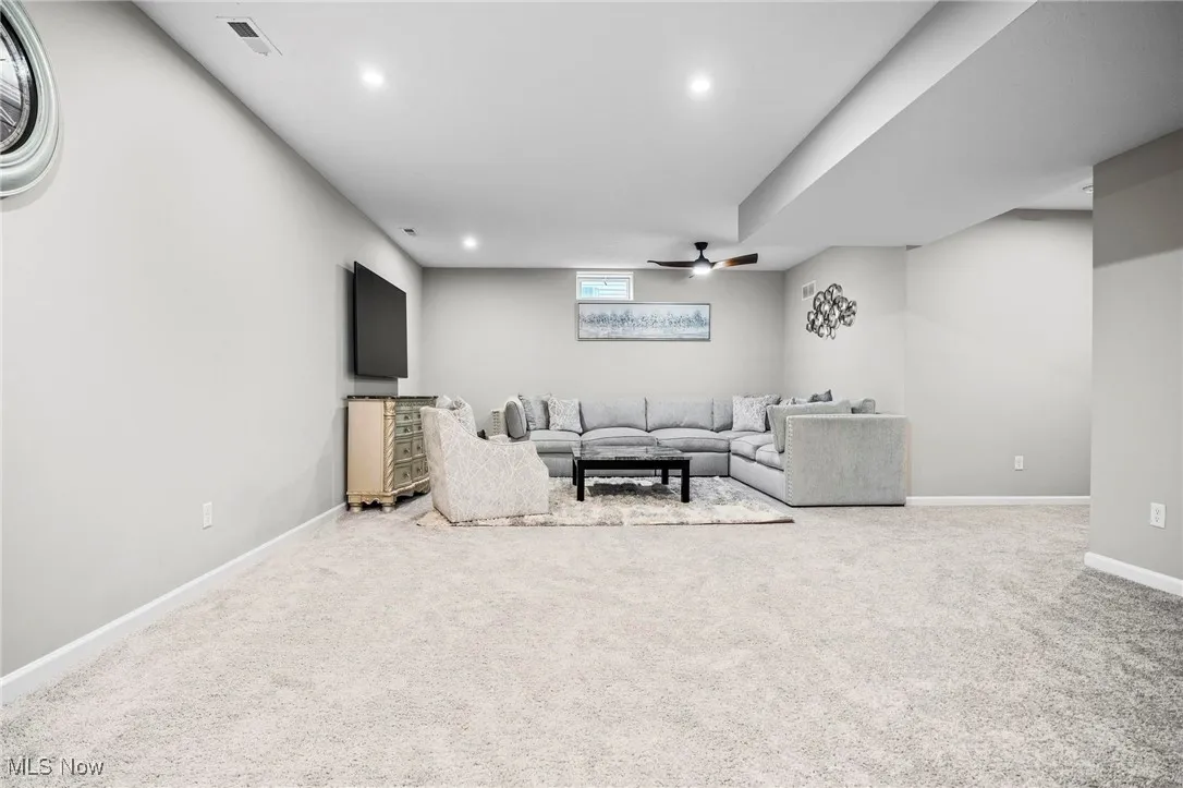 Living area with carpet, ceiling fan, and recessed lighting