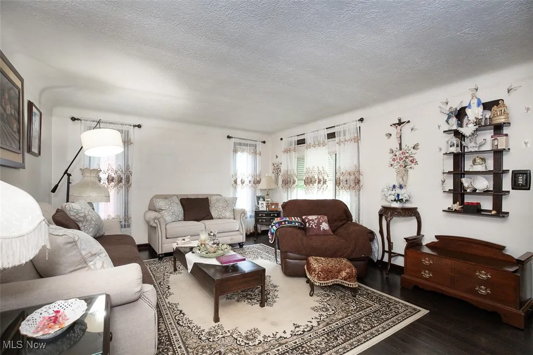 Living room with a textured ceiling and wood flooring.