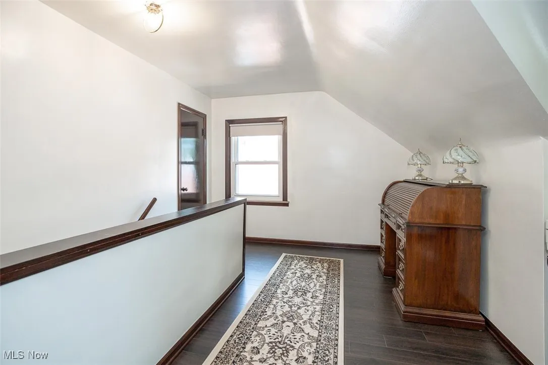 Hall featuring an upstairs landing,  wood flooring, and lofted ceiling.