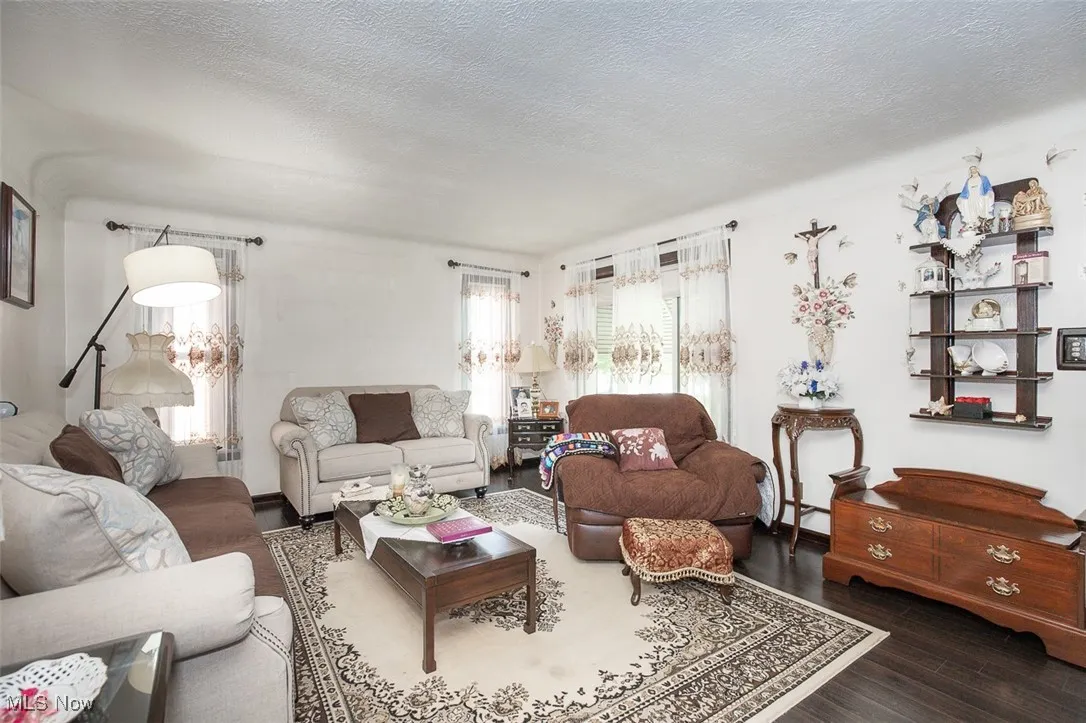 Living area featuring a textured ceiling and wood flooring.