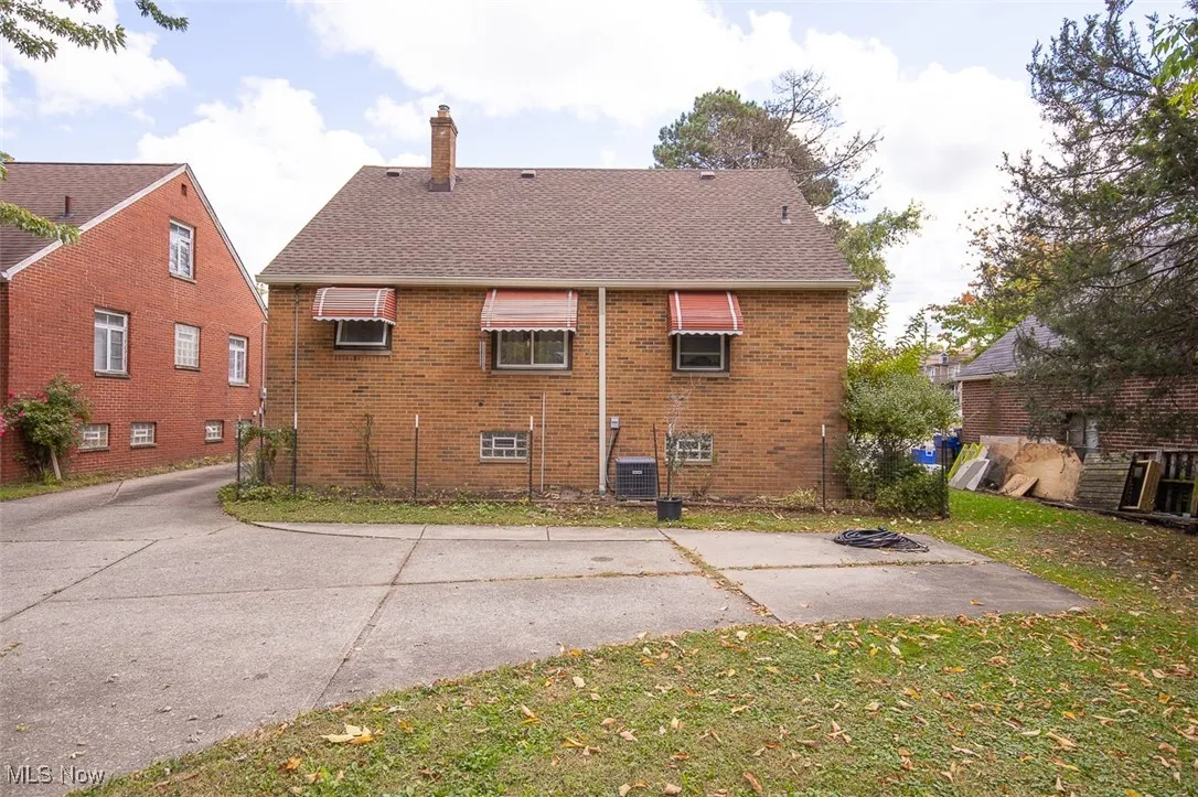 Back of house featuring driveway extension for extra parking space.