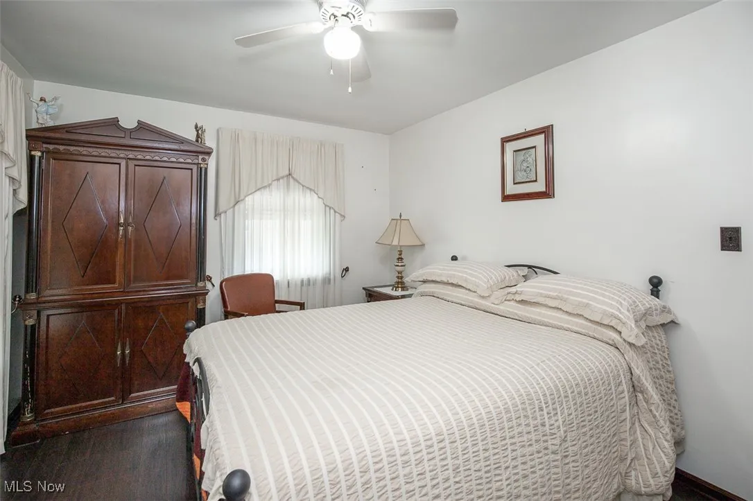 First floor bedroom featuring a ceiling fan and wood flooring.