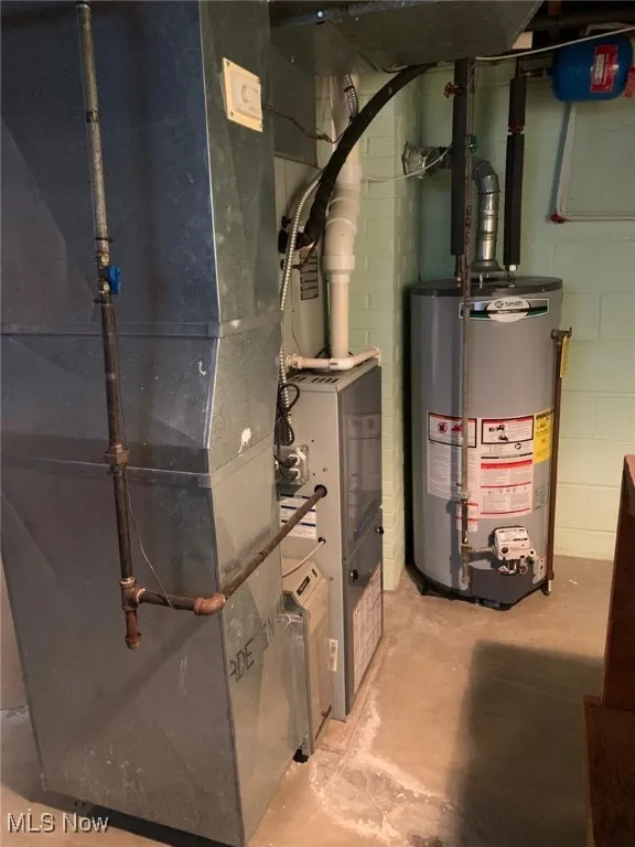 Utility room featuring heating unit and gas water heater
