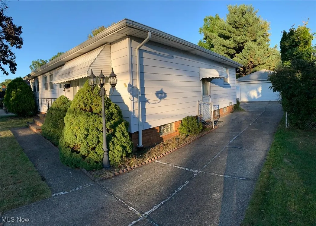 View of side of home featuring an outdoor structure and a detached garage
