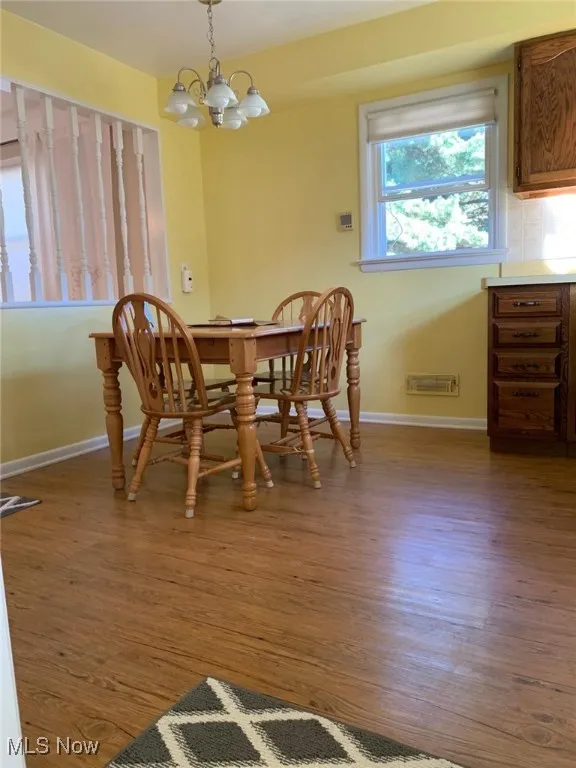 Dining space featuring dark wood finished floors and a chandelier