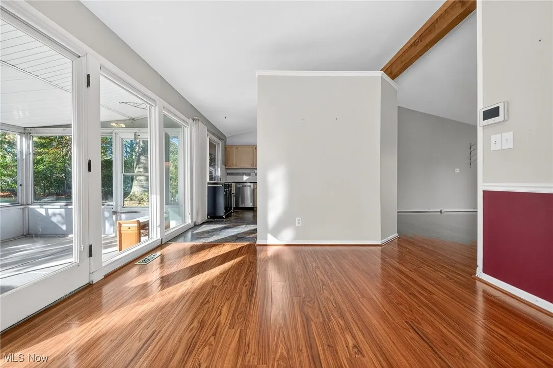 Unfurnished living room featuring dark wood finished floors and baseboards