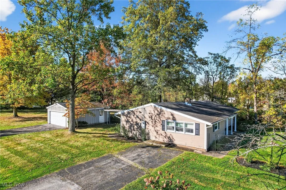 View of front of house with an outbuilding, a front lawn, and view of scattered trees