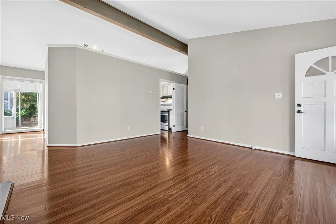 Unfurnished living room with dark wood-type flooring