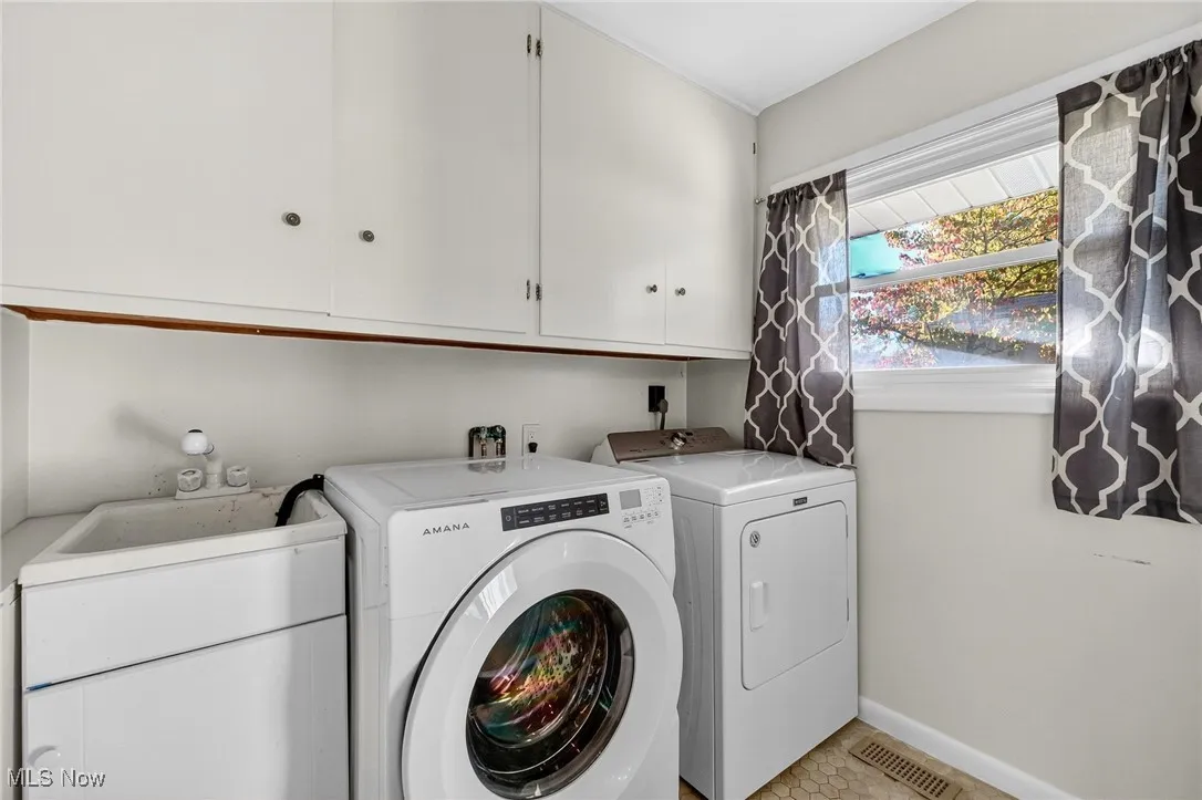 Laundry area featuring washing machine and clothes dryer and cabinet space