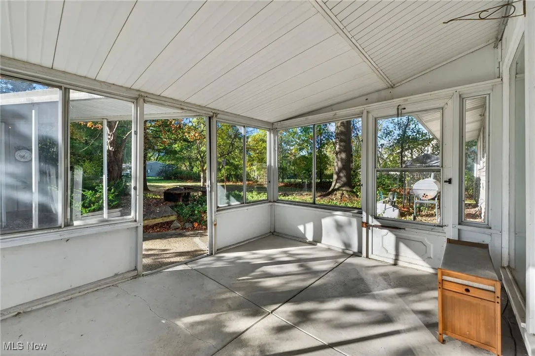Unfurnished sunroom with lofted ceiling