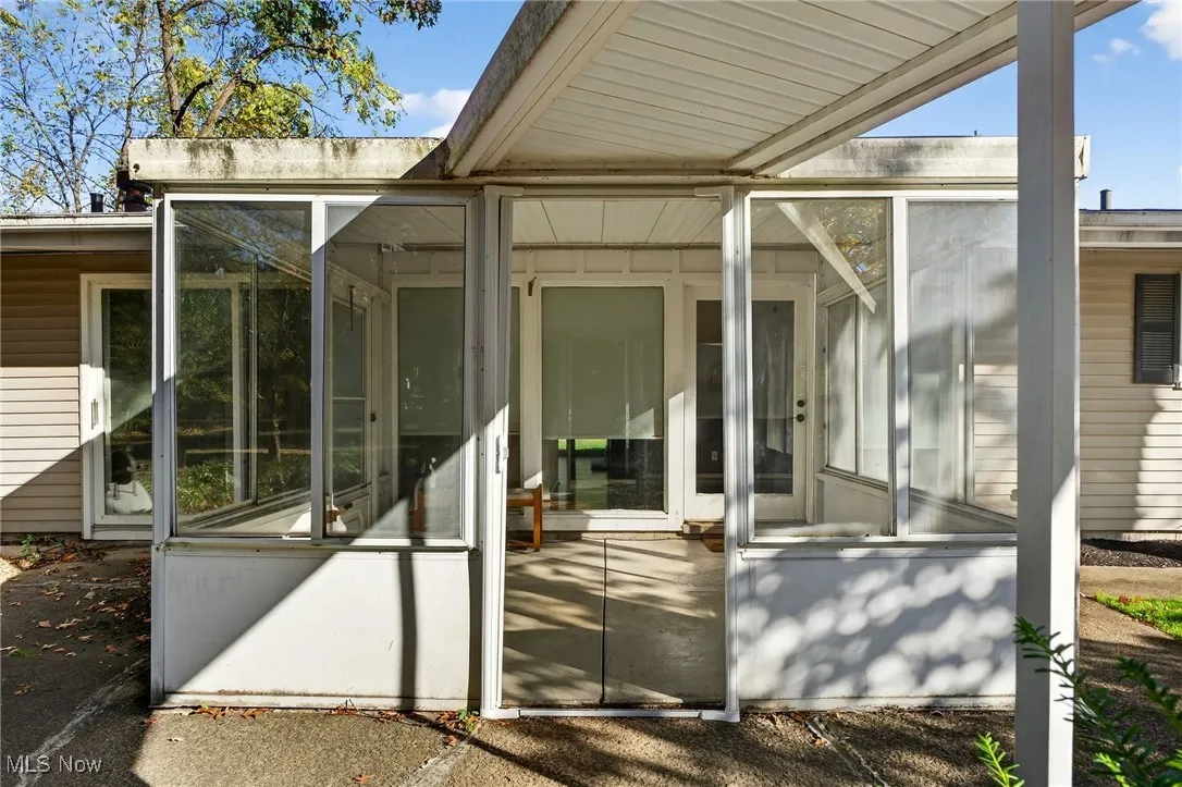 Doorway to property featuring a sunroom