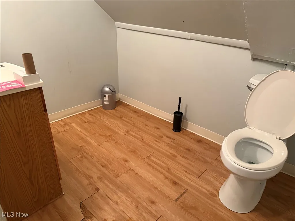 Bathroom with light wood-style flooring and toilet