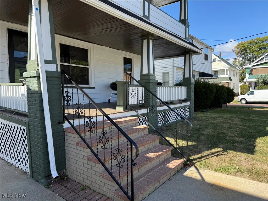 Entrance to property with a porch and a lawn