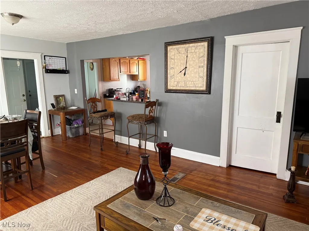Living area featuring dark wood-style floors and a textured ceiling